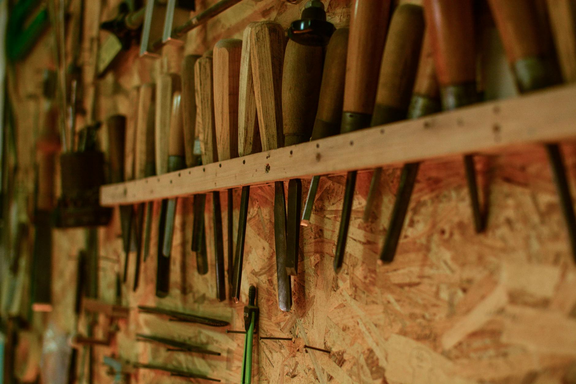 Outils d'ébéniste alignés sur un mur d'atelier — l'artisanat au cœur du métier